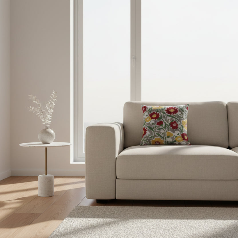 brodert pute med blomster i rødt, gult, grønt og hvit i sofa