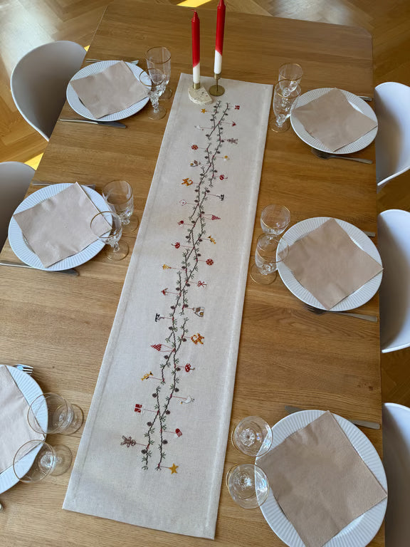 Julestemningløper på trebord som er oppdekket