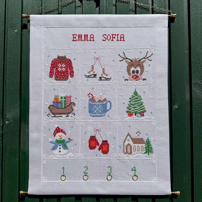 Vinter adventskalender hengt opp på grønn vegg
