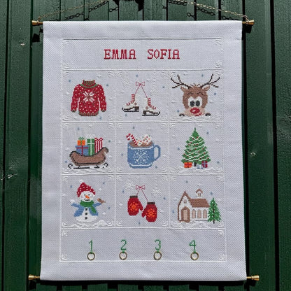 Vinter adventskalender hengt opp på grønn vegg
