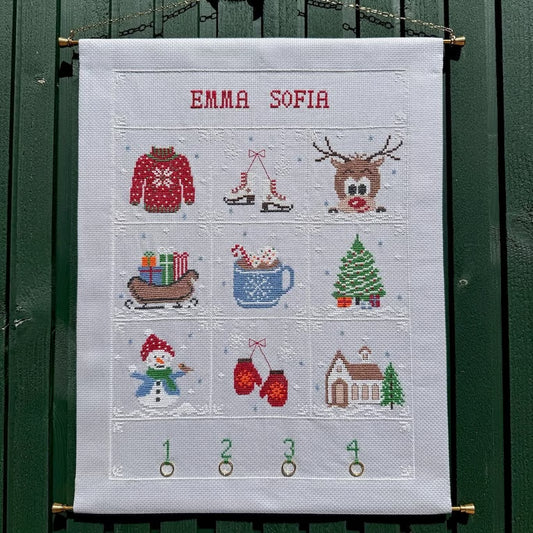 Vinter adventskalender hengt opp på grønn vegg