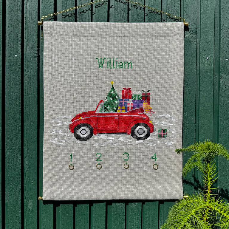 Gavebil adventskalender hengt opp på grønn vegg