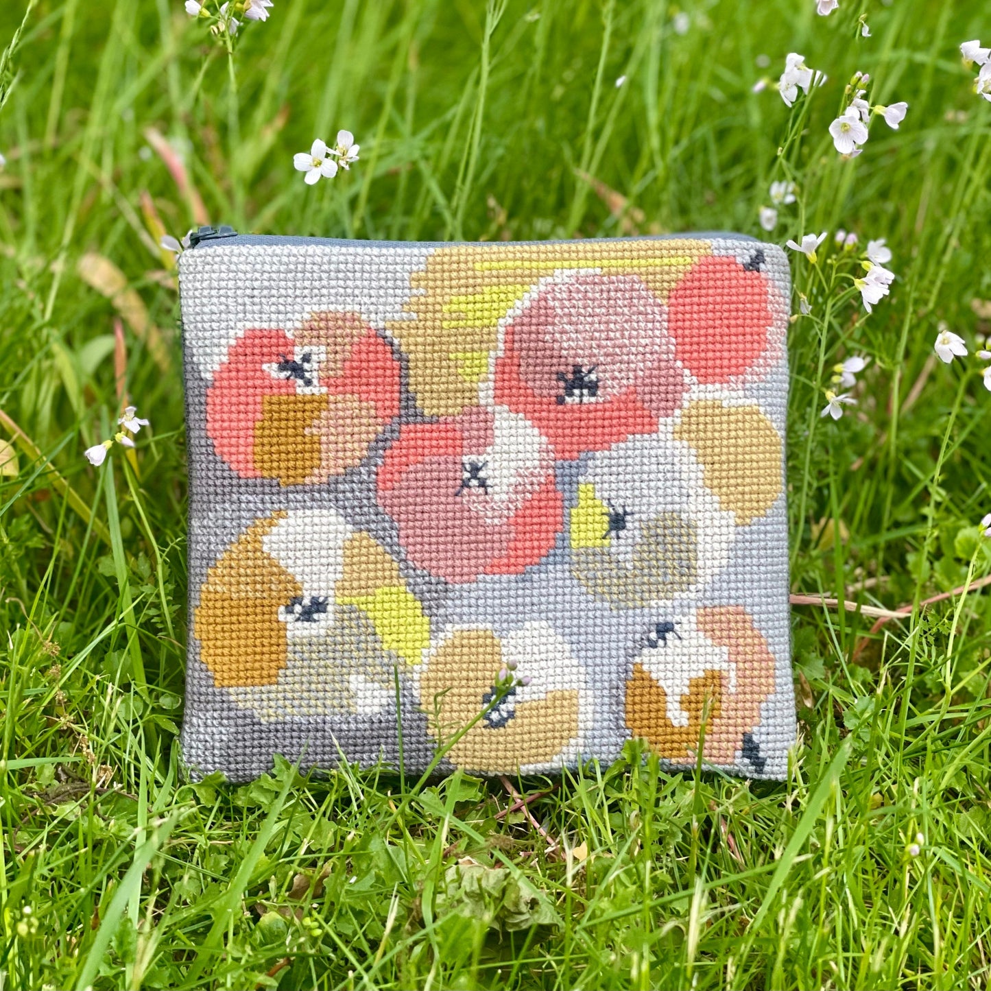 Æbler clutch ferdig brodert. Plasser på en gressbakgrunn. Mønster består av epler