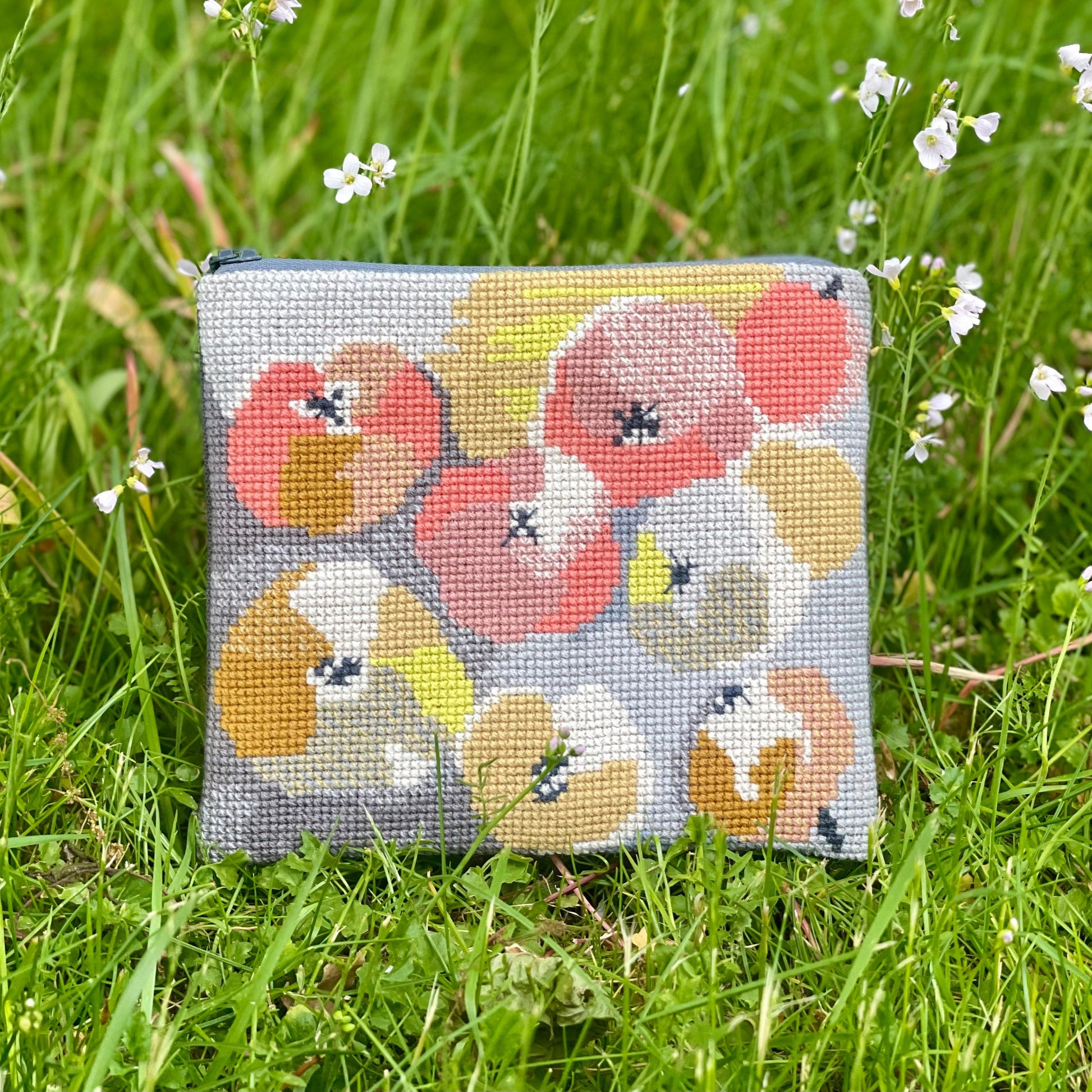 Æbler clutch ferdig brodert. Plasser på en gressbakgrunn. Mønster består av epler