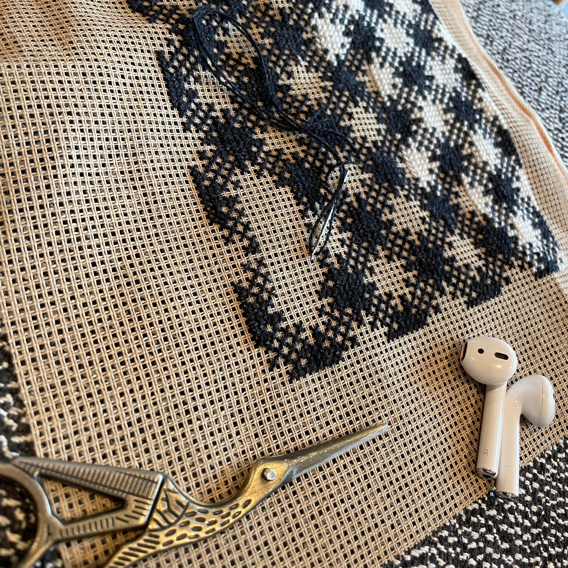 Nærbilde av chic broderi med storkesaks og airpods