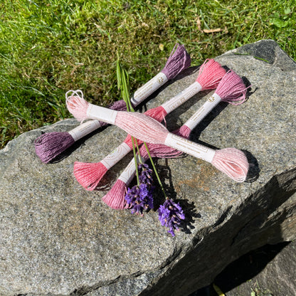 Rosa og lilla garnnøster på gråstein
