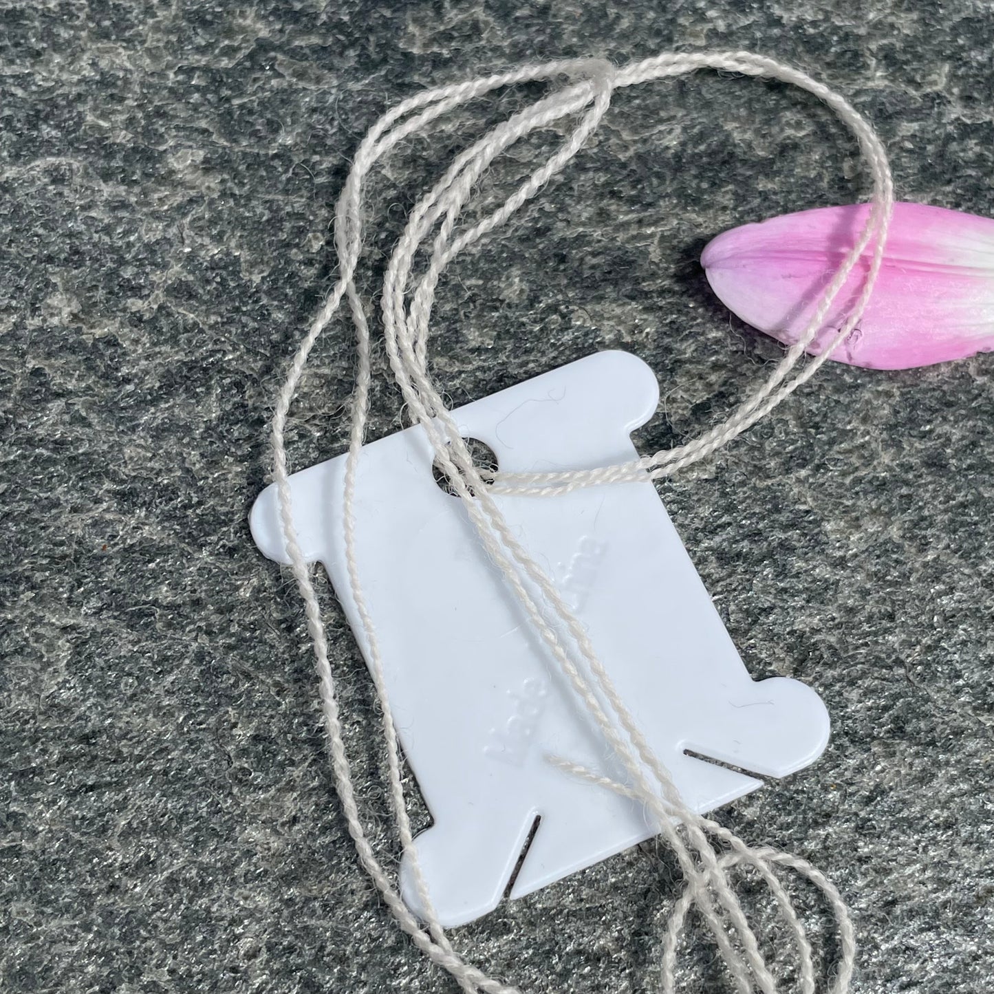 Garnvindsler i plast på grå bakgrunn