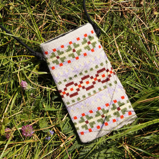 Kunna mobilveske ferdig broderi liggende på gresset