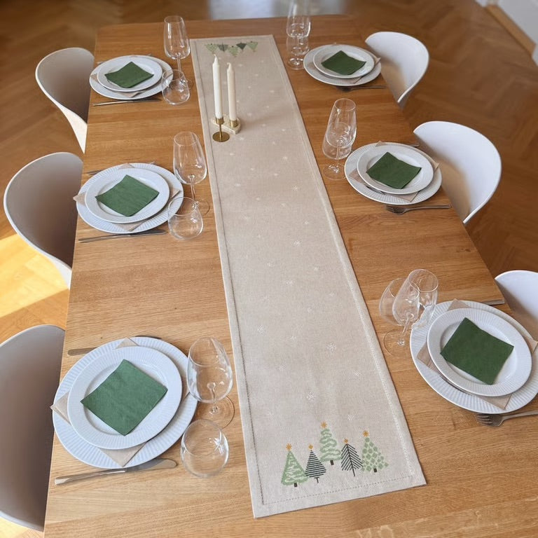 Lang grønn juleløper på dekket bord