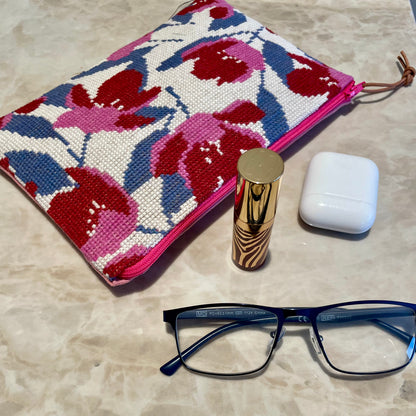 Ferdig magnolia clutch med nydelig magnolia mønster, lebestift, briller og airpods