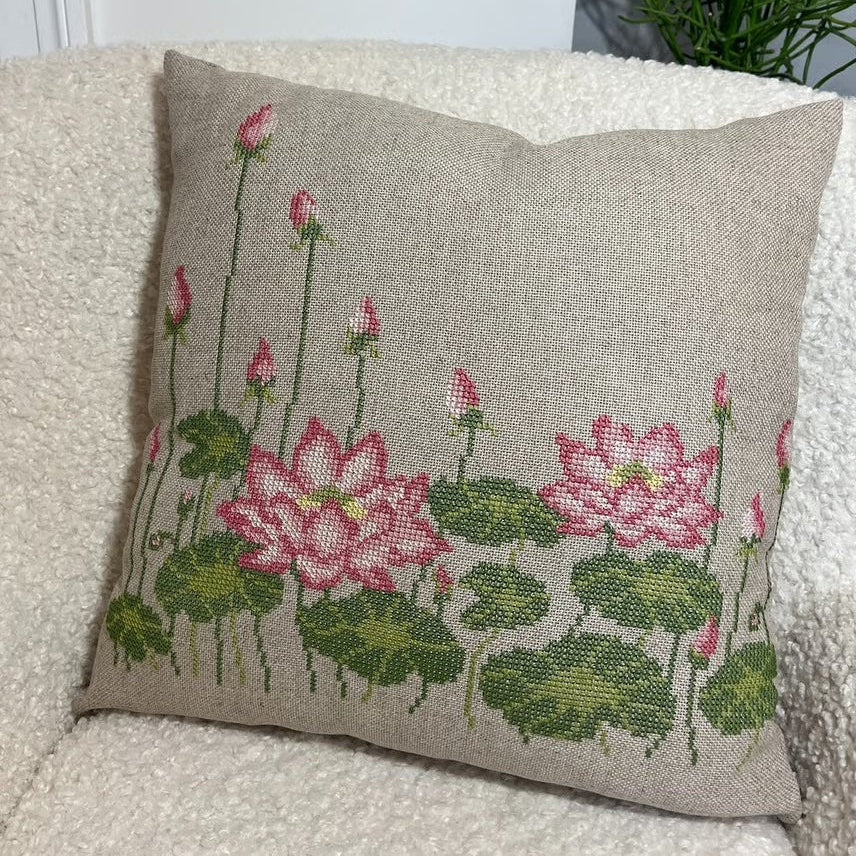 Pink lotus brodert pute i hvit fluffy stol