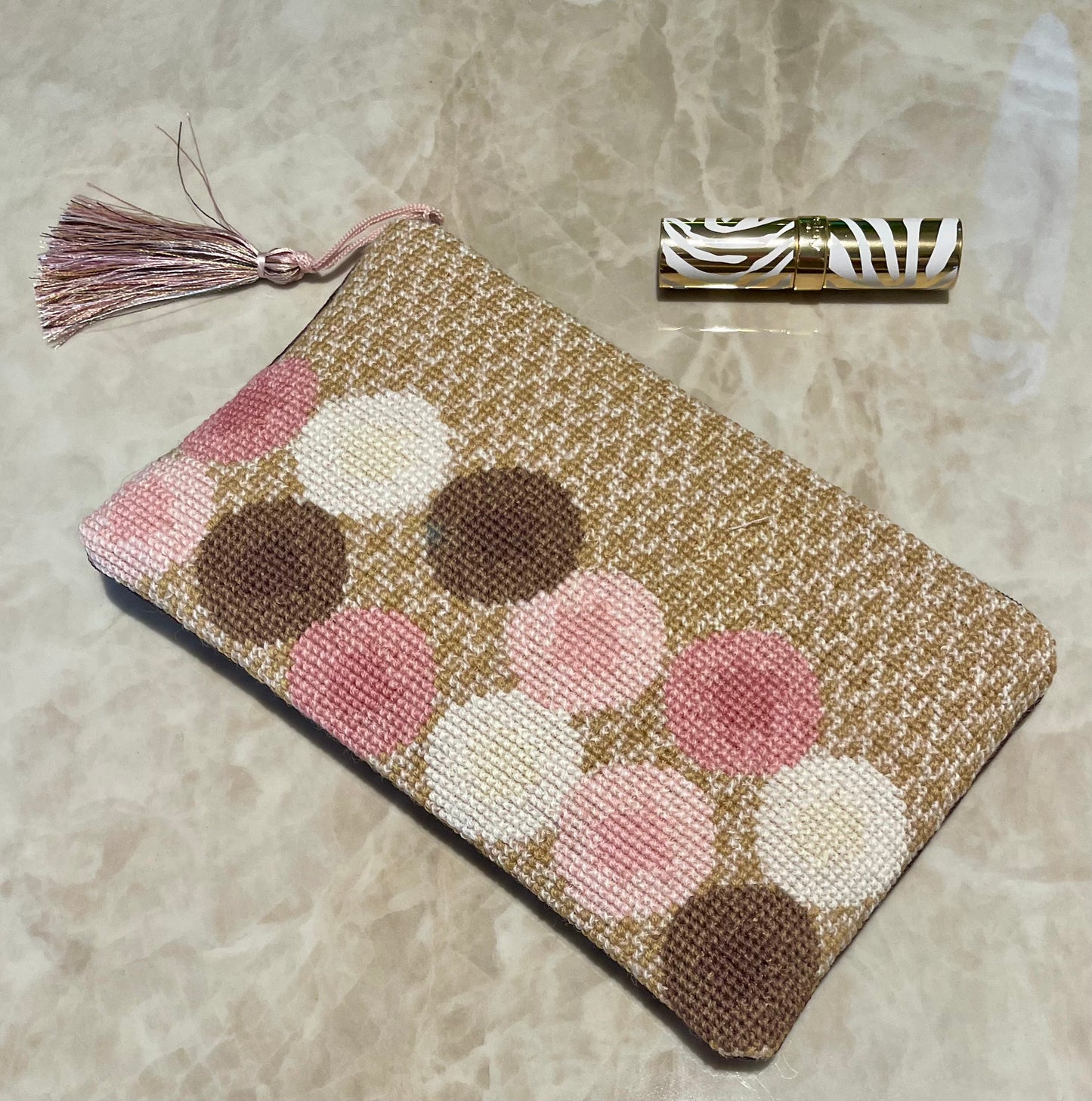 Ulla clutch i fargene gull, rosa, brun og hvit med dusk og lebestift