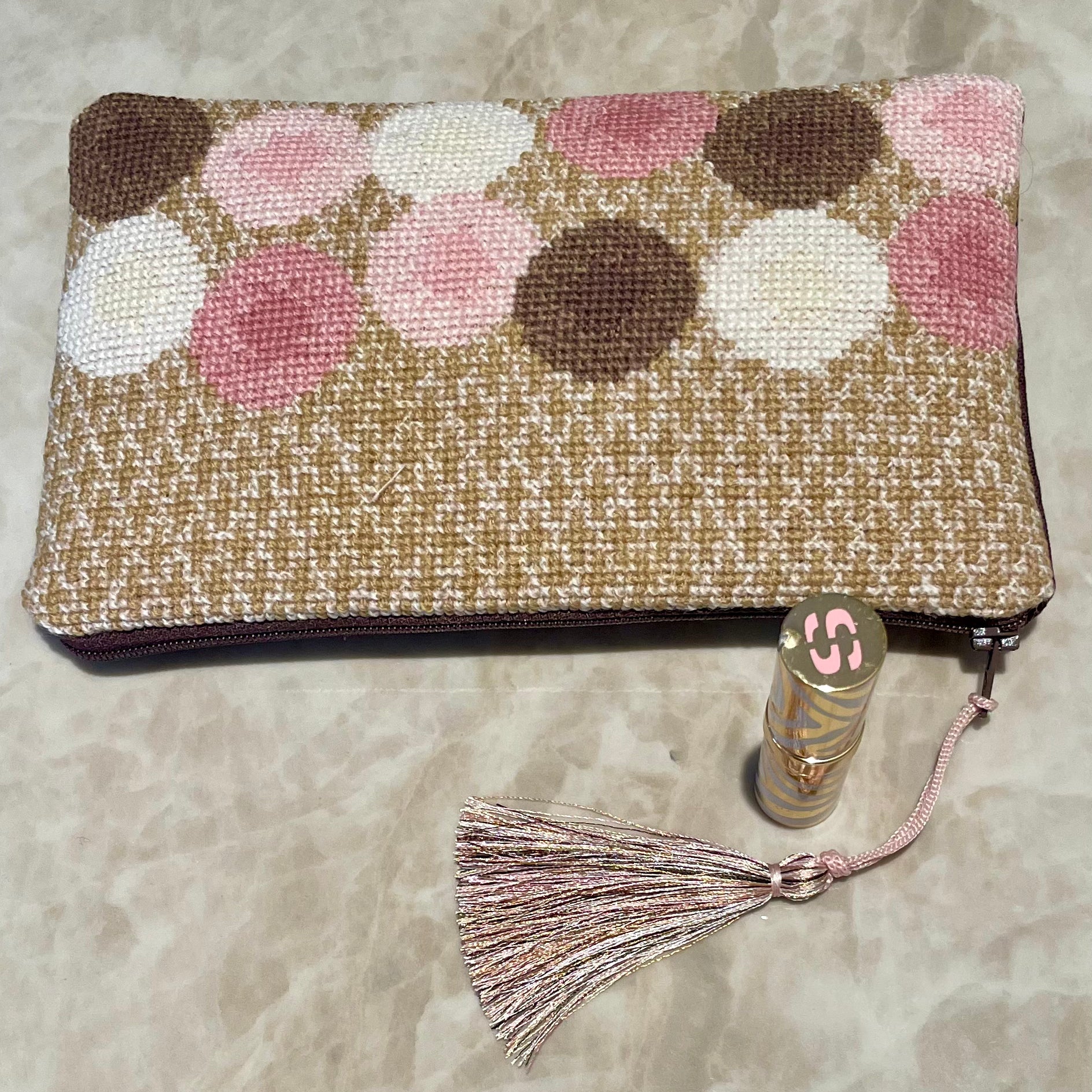 Ulla clutch i fargene gull, rosa, brun og hvit med dusk og lebestift