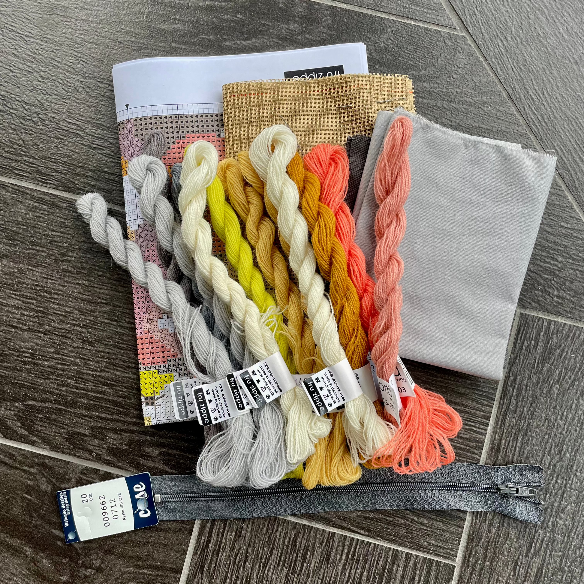 Innhold i Æbler broderikit: stramei, garn, bakstykke, for, glidelås og mønster
