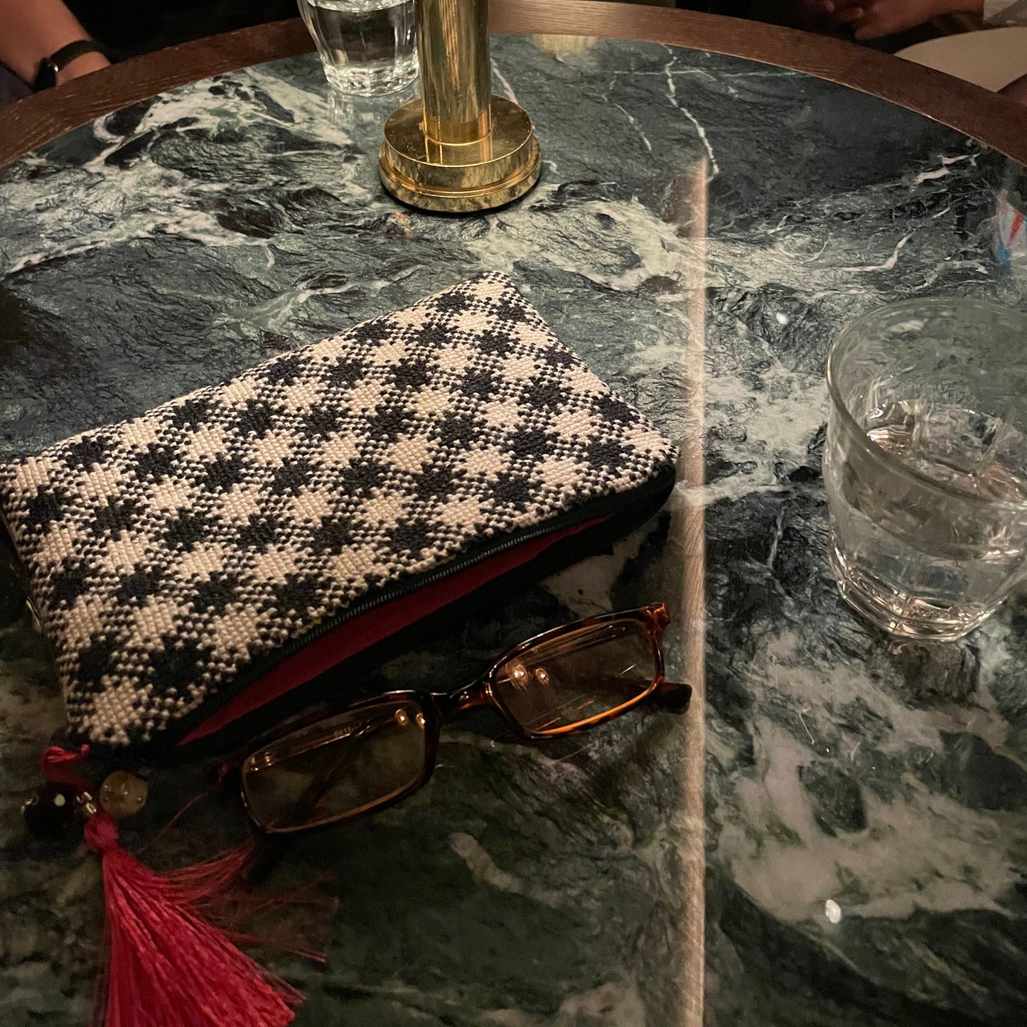 chic i bruk liggende på bord med briller og et glass vann