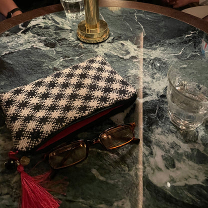 chic i bruk liggende på bord med briller og et glass vann